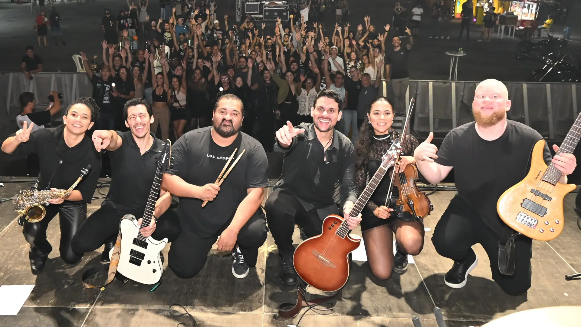 Os seis músicos da Banda 4G no palco com sax, guitarra, baquetas, violão, violino e contrabaixo